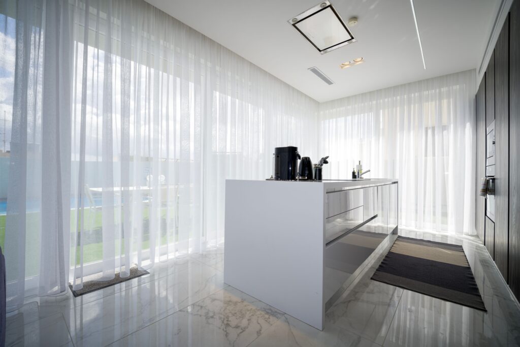 Bright modern kitchen with sheer curtains in a luxury villa located in St. Julian's, Malta.
